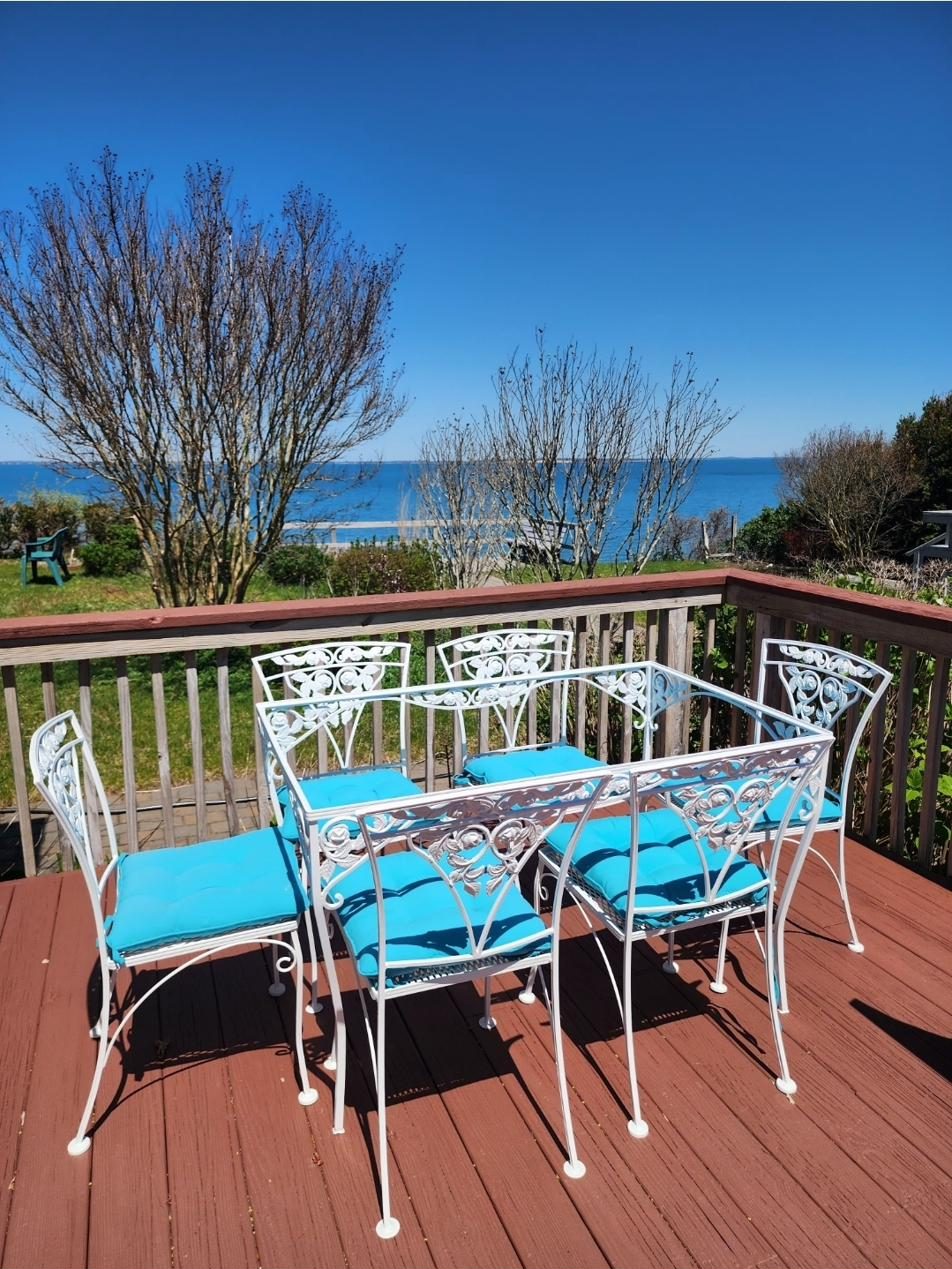 East deck at Cottage 1 with a wrought-iron table and chairs overlooking Peconic Bay