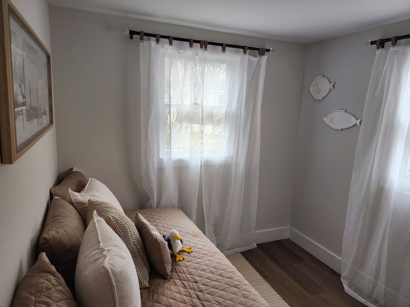 Bedroom at Cottage 2 with a high-riser bed and playful East End whale-themed details.