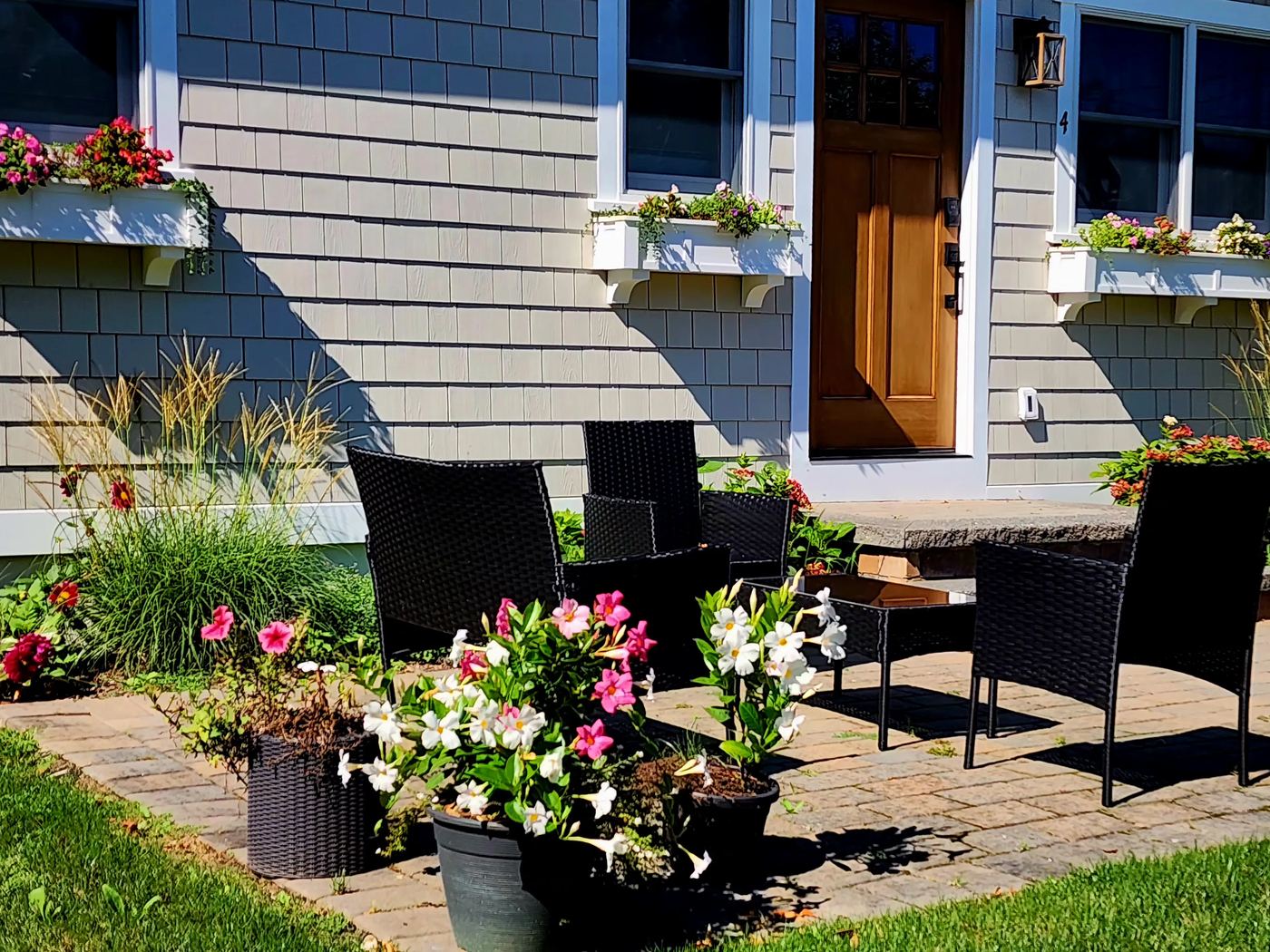 Front entrance of Cottage 4 with window flower boxes and a paver patio