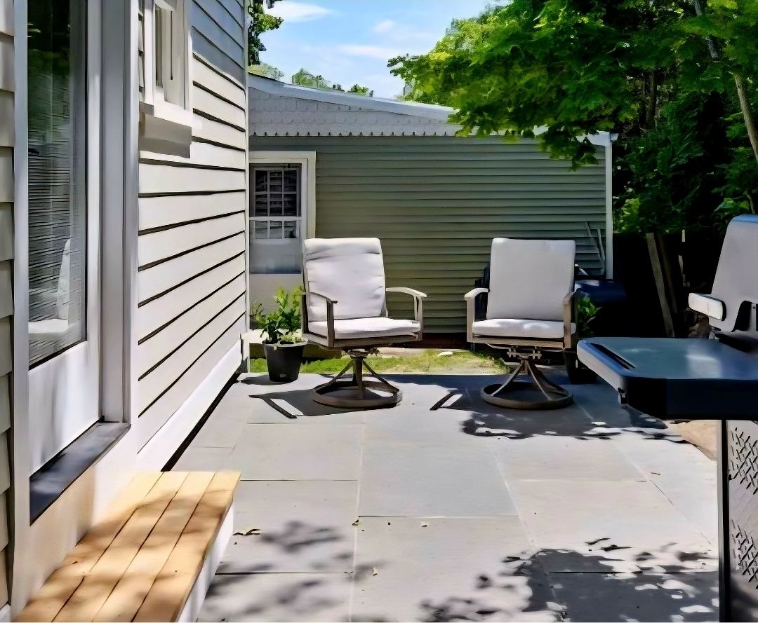 Rear bluestone patio at Cottage 4 with swivel seating tucked beneath the trees