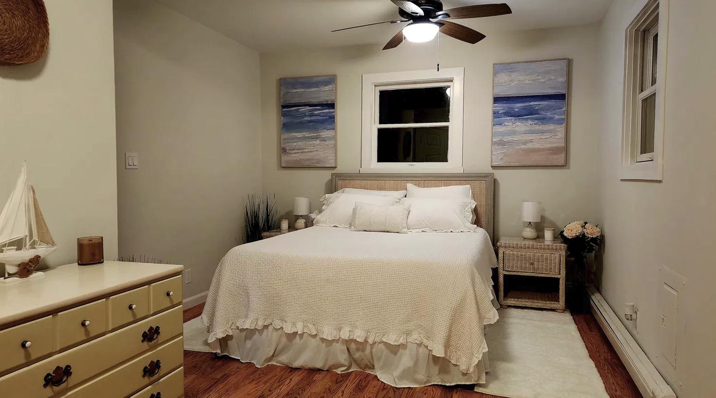 The beach-themed primary bedroom, with coastal artwork above the bed