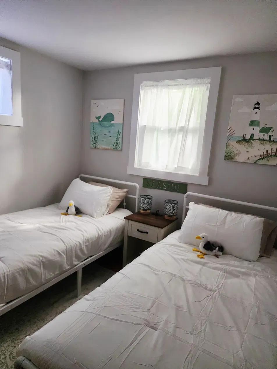 The second bedroom, with two twin beds and hand-painted whale and lighthouse artwork