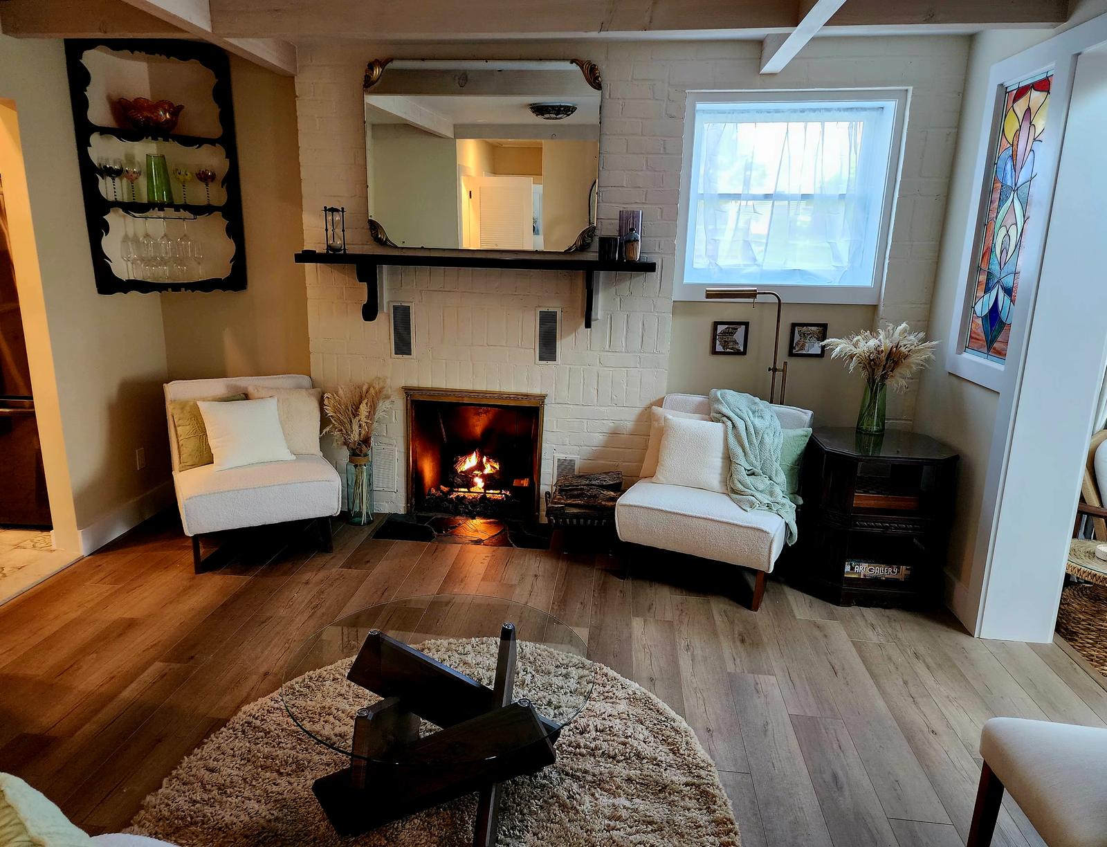 The fireplace lit, flanked by boucle chairs