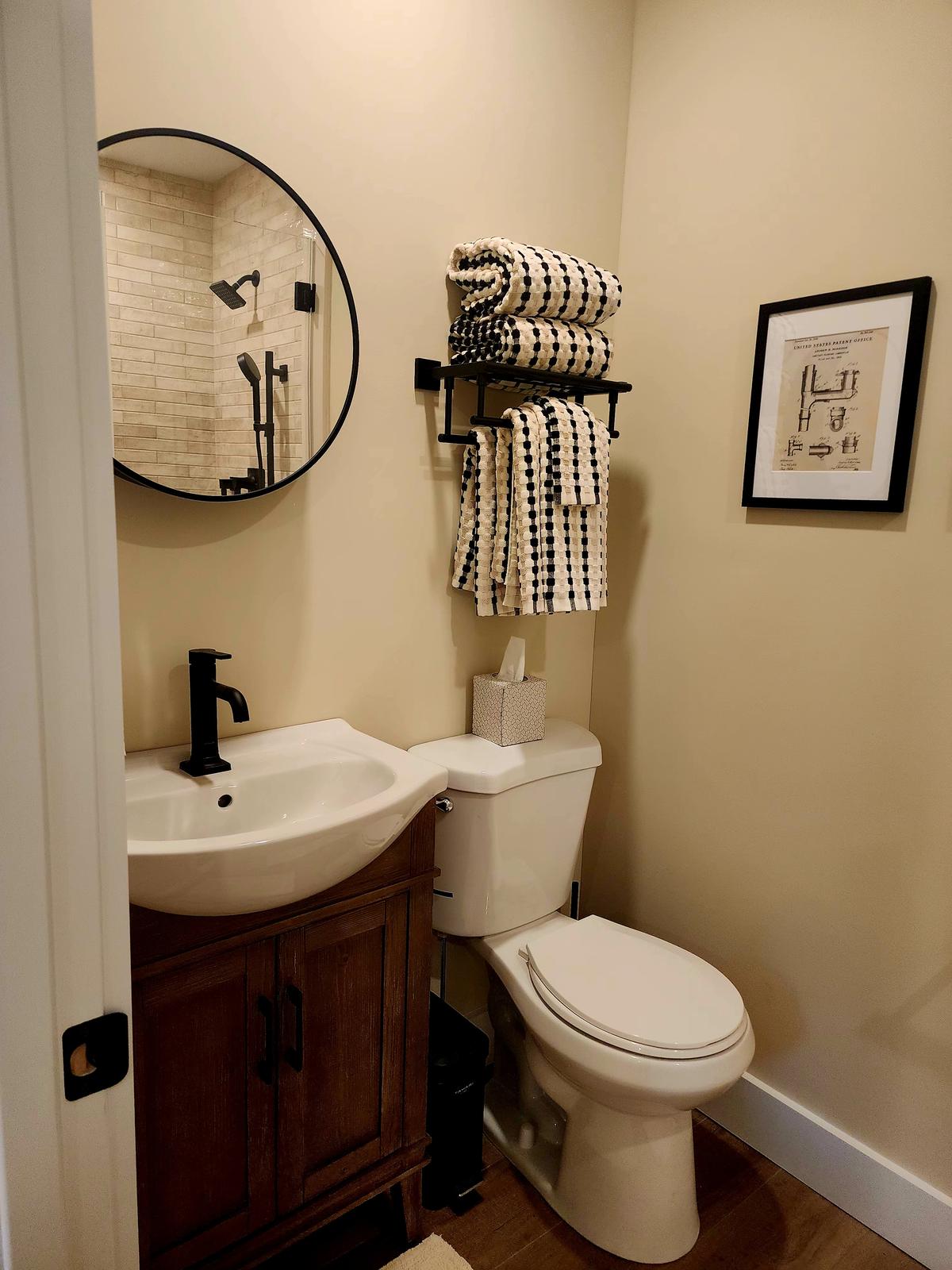 Full bathroom in the primary suite, with black fixtures and framed vintage art