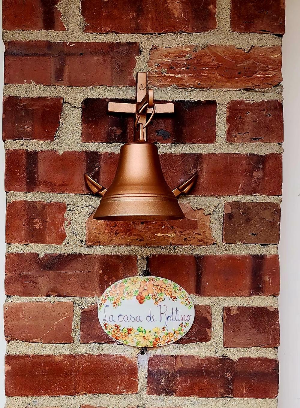 The original bell and hand-painted ceramic sign at the front door