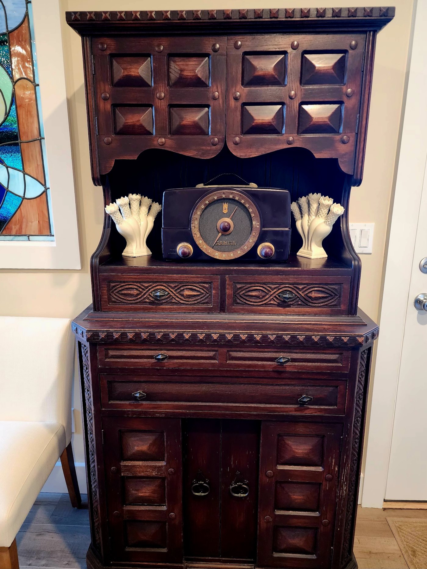 The fireplace room's original carved dark-wood cabinet, with a vintage Zenith radio