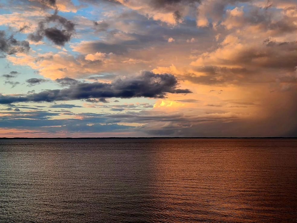 Sunset with visible rain in the distance over the bay