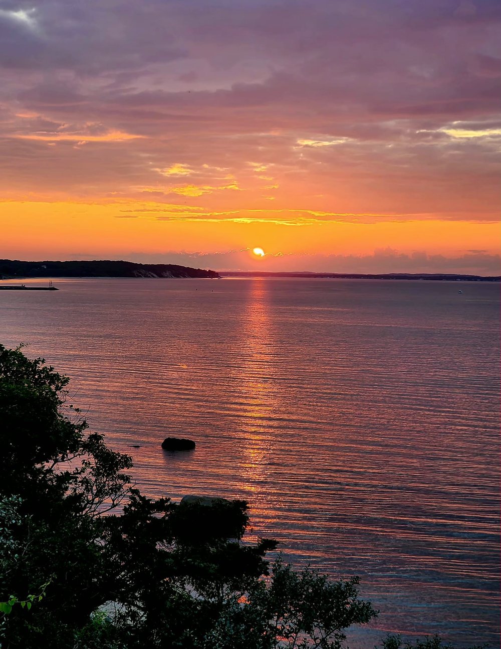 Magenta and gold sunset clouds reflected across Peconic Bay