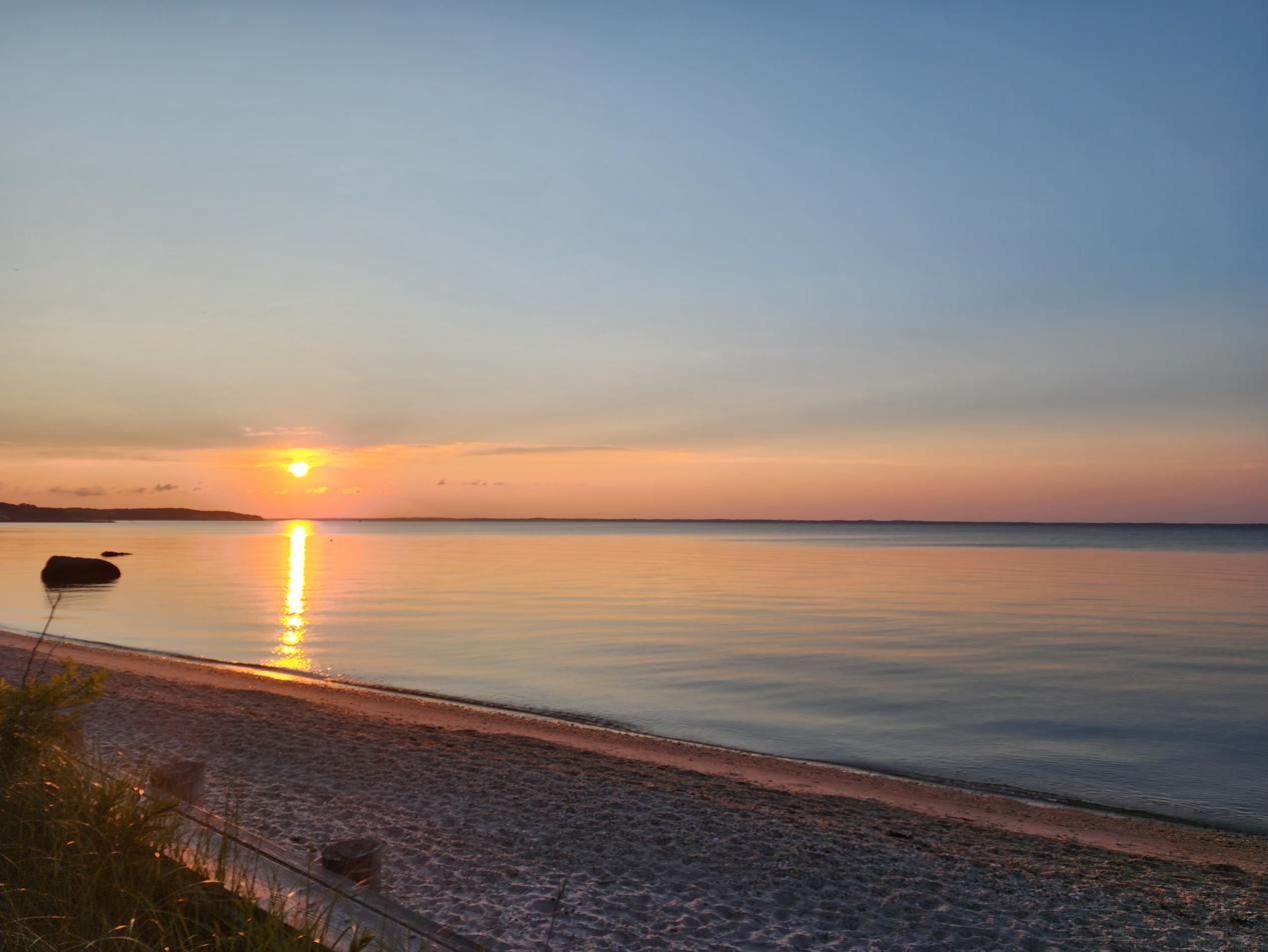 A quiet beach sunset with the sun low over the water