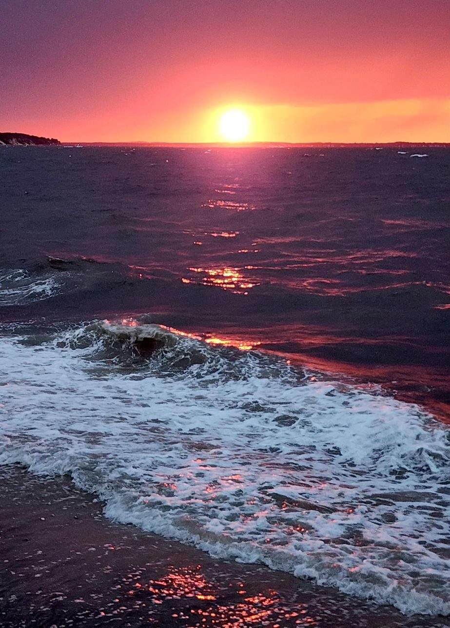 Waves breaking on the beach lit by a golden sunset