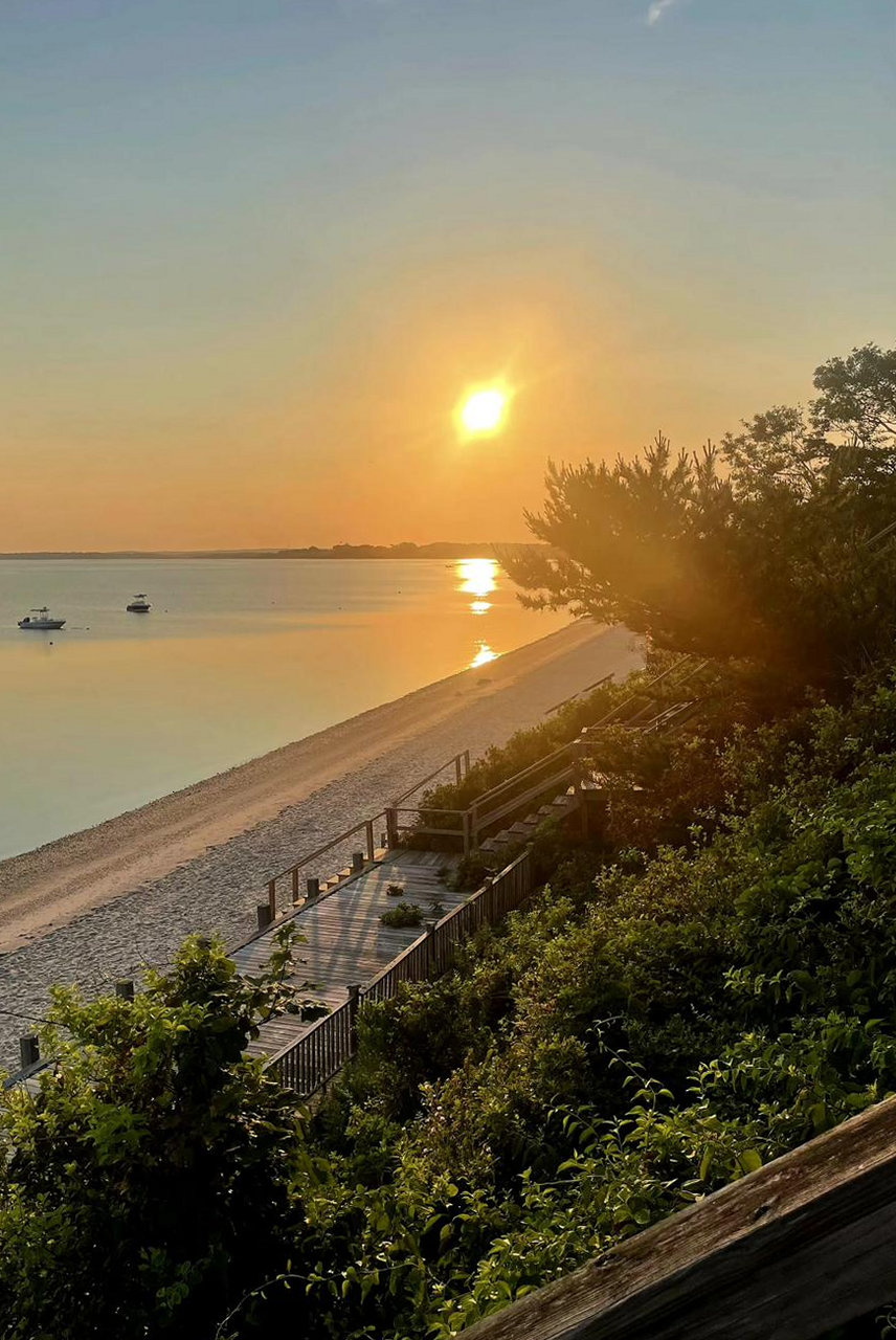 Sunrise over the beach and bay, with the stairs leading down to the water