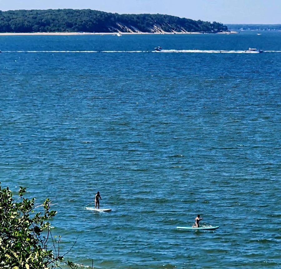 Stand-up paddleboarders on calm water near Peconic View Cottages